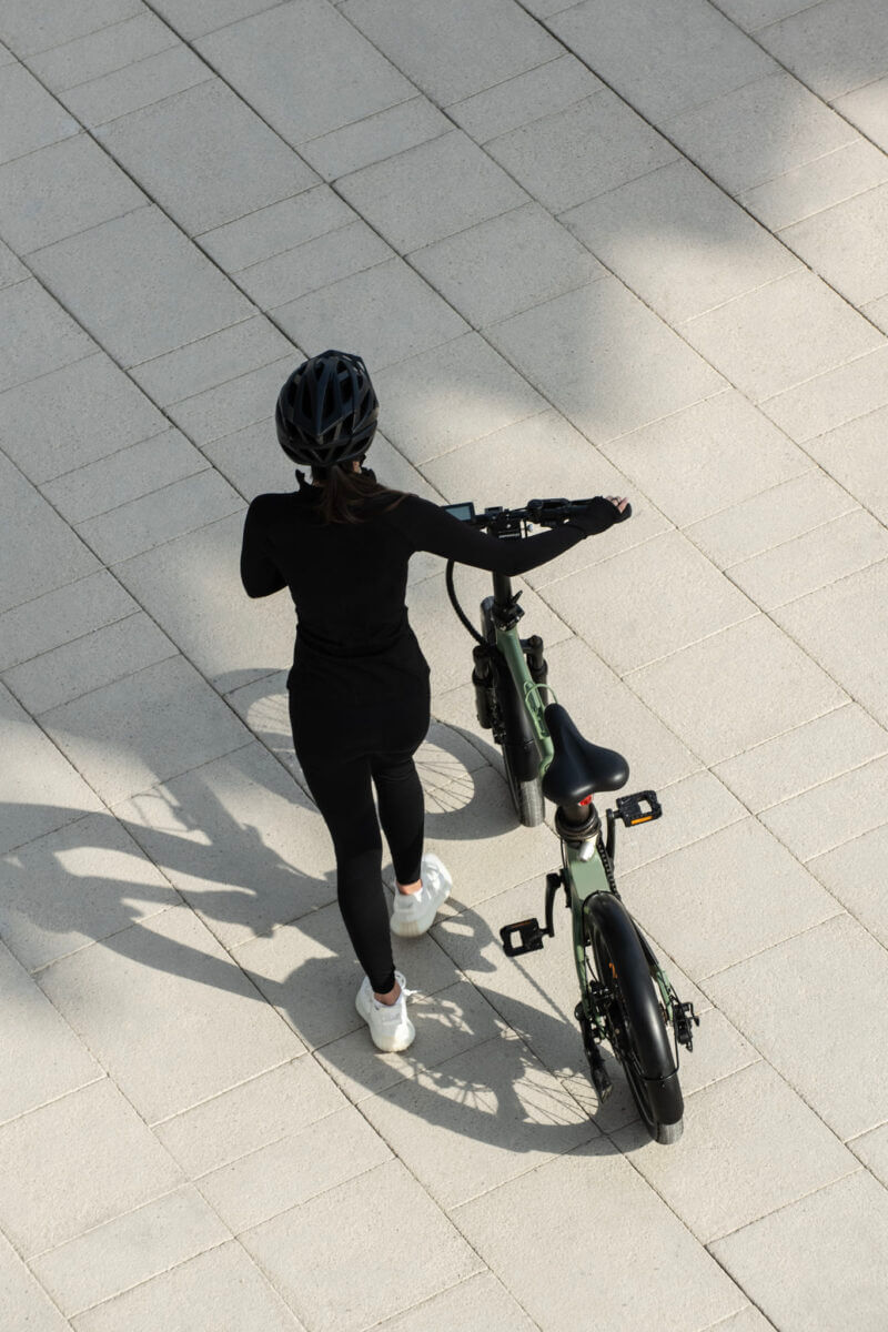 Biyiy Experience - Single woman walking a bike in the Dubai