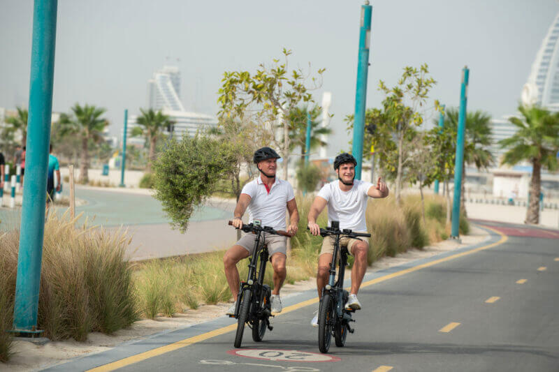 Biyiy Experience - 2 men riding their e-bikes on the beach of Dubai